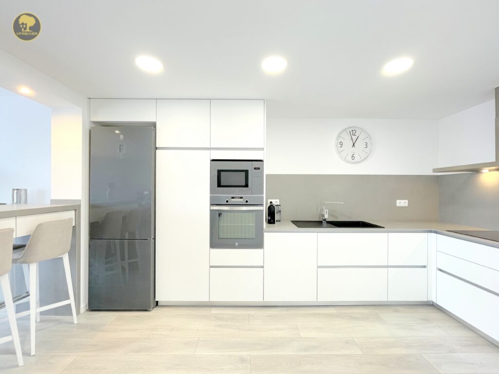 a kitchen with a white wall and a refrigerator