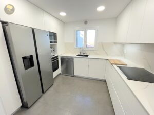 a kitchen with white cabinets and appliances