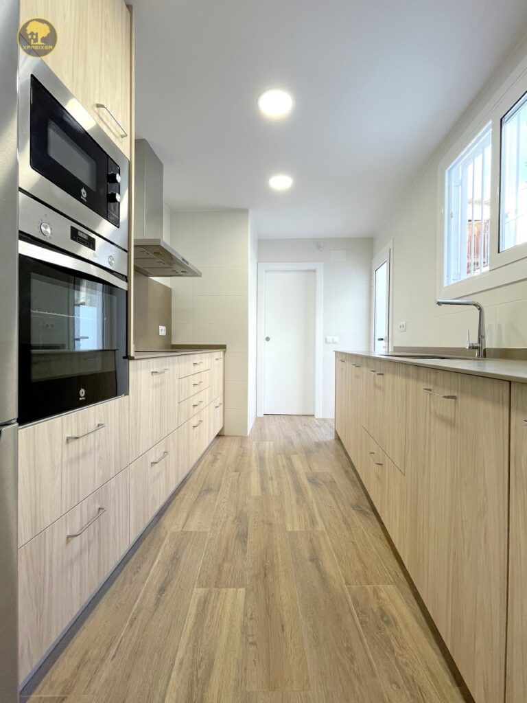 a kitchen with wood cabinets and a wood floor